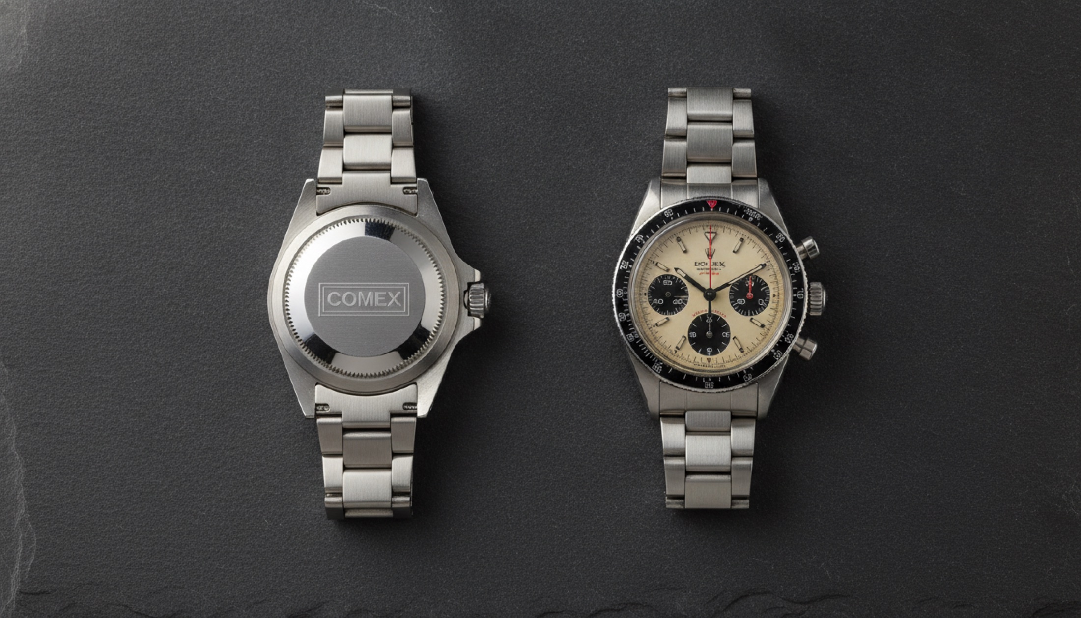 Artcurial Monaco müzayedesine giren iki vintage Rolex — COMEX Sea-Dweller ve Paul Newman kadranı — koyu taş yüzeyde sergilenmiş