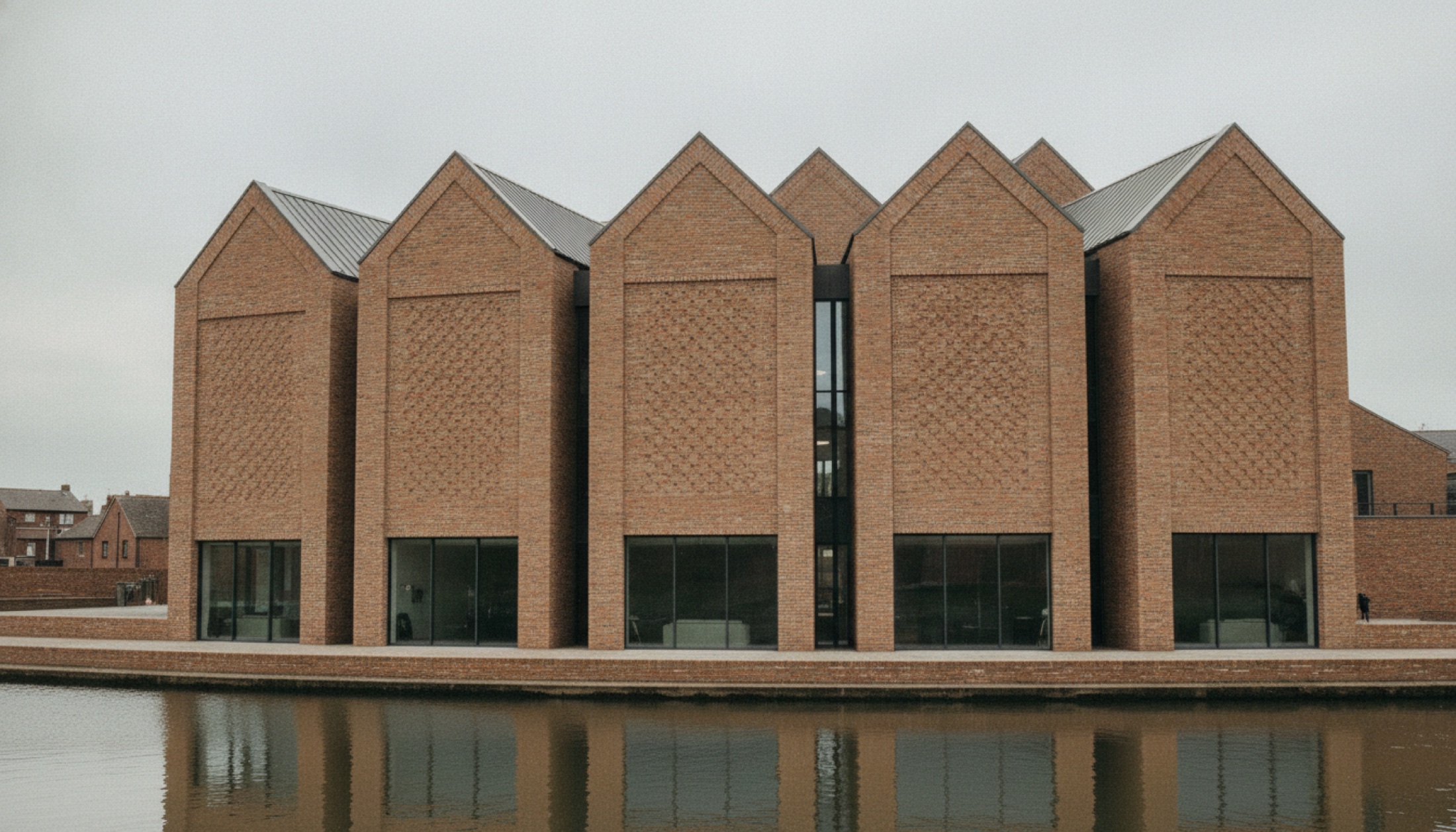 BEAM sanat merkezi Hertford, beş tuğla kütle ve eğimli çatılarıyla nehir kıyısında; Bennetts Associates tasarımı, RIBA Stirling 2026 kısa listesi.