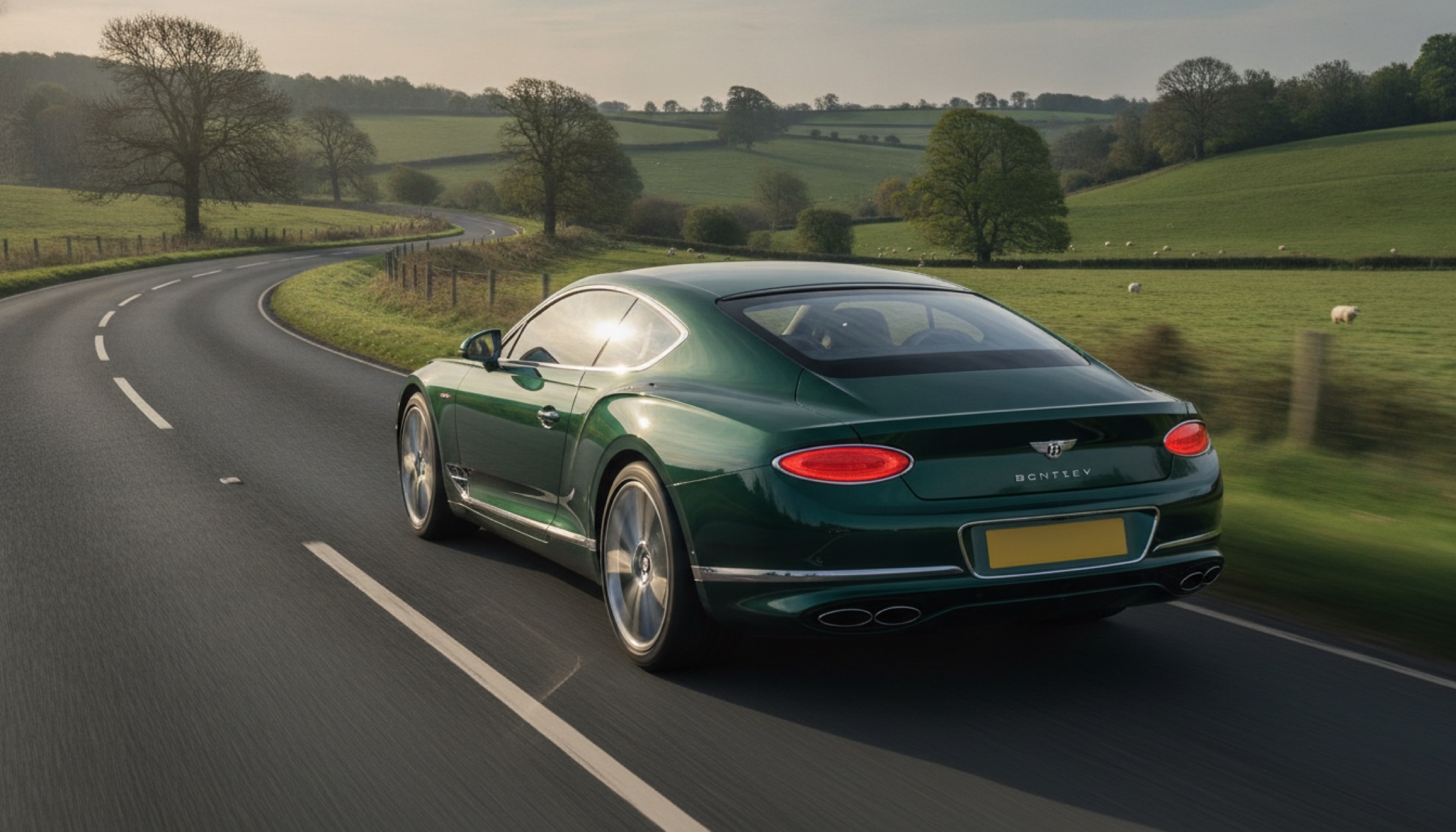 2026 Bentley Continental GT Supersports kıvrımlı bir İngiliz yolunda, arkadan açı, koyu yeşil renk