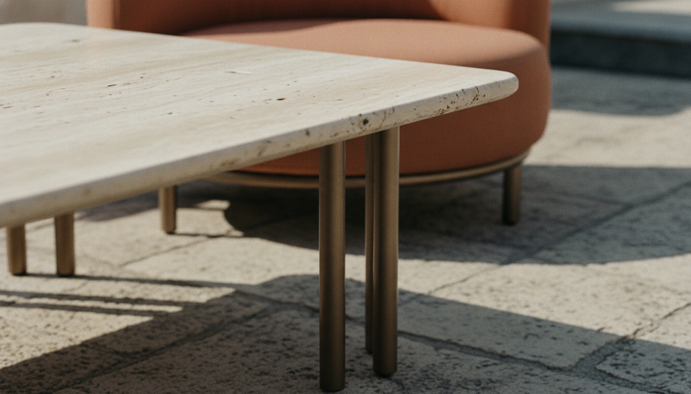 Cassina Vidalenta açık hava koleksiyonu — Roma travertin tabla ve küçük çaplı metal boru iskelet, terrakota döşeme arka planda.