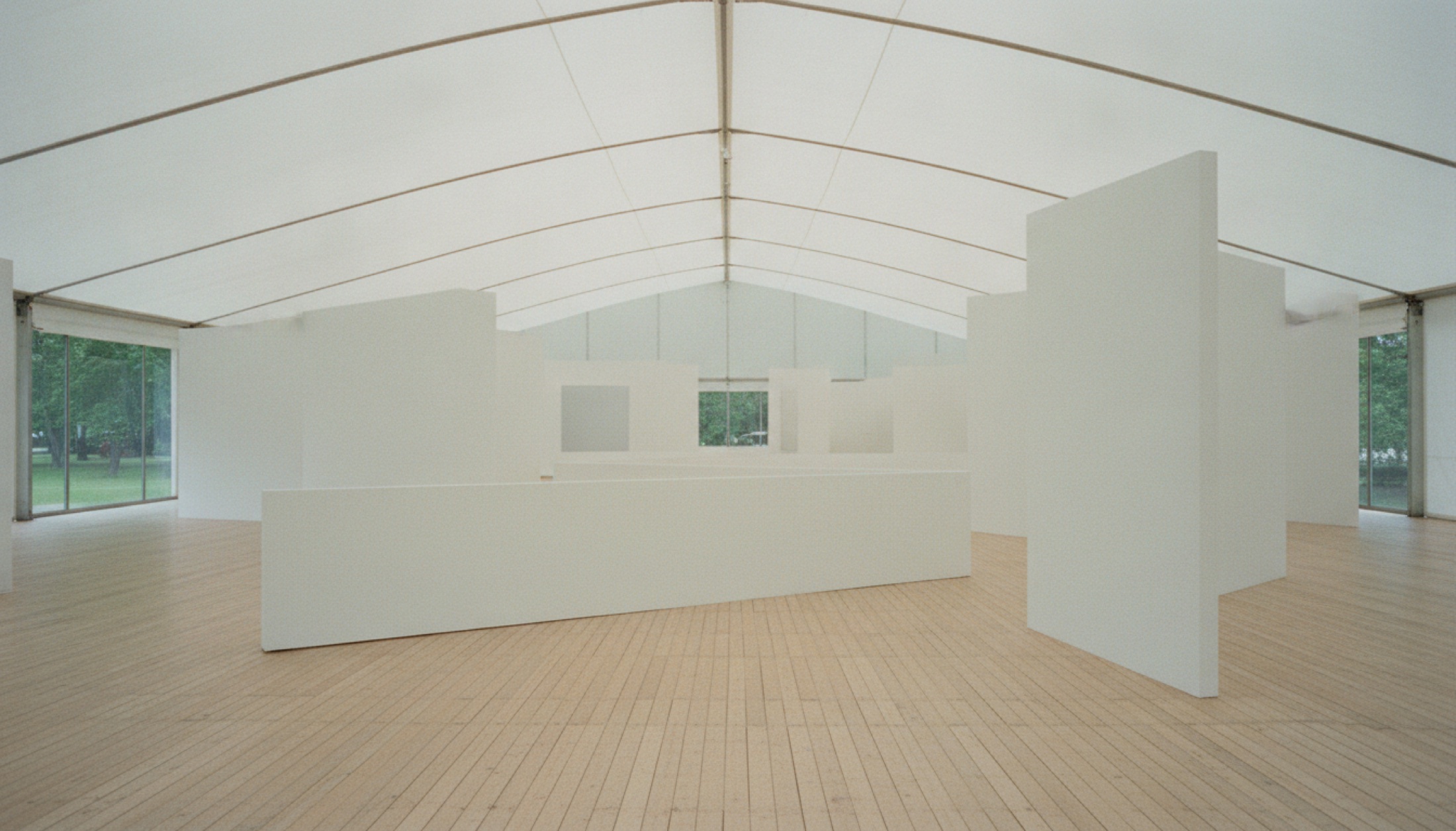 Frieze London fuar alanının boş holü — beyaz bölücü duvarlar, ahşap zemin, doğal ışık