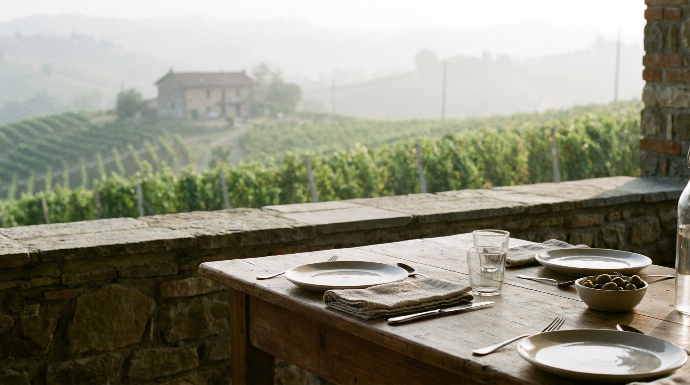 Serralunga d'Alba tepelerinde Barolo bağları arasında bir masa düzeni, Langhe'nin kışlık puslu manzarası