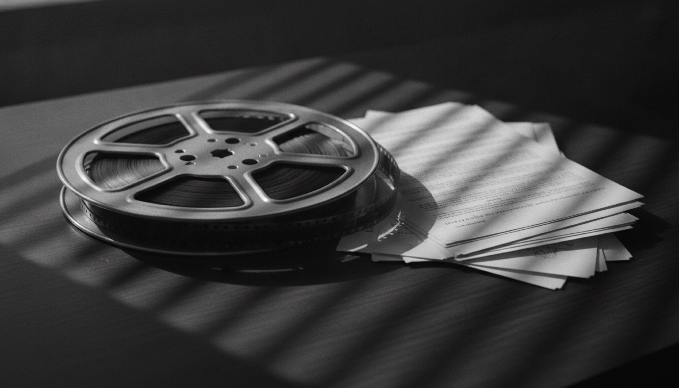 1950'ler Hollywood siyah-beyaz fotoğraf: film makarası ve senaryo kağıtları üzerinde jaluzi gölgeleri, noir aydınlatma