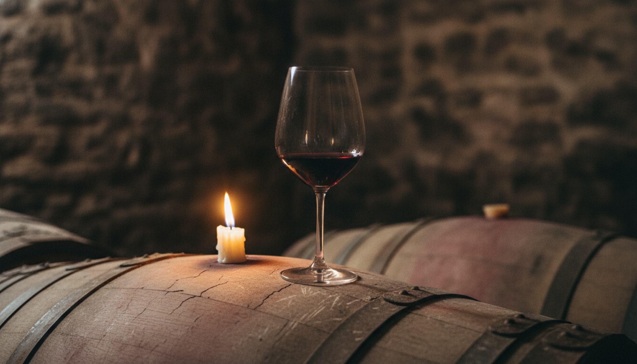 Médoc chai'sinde meşe fıçının üzerinde duran Bordeaux kadehi, mum ışığı