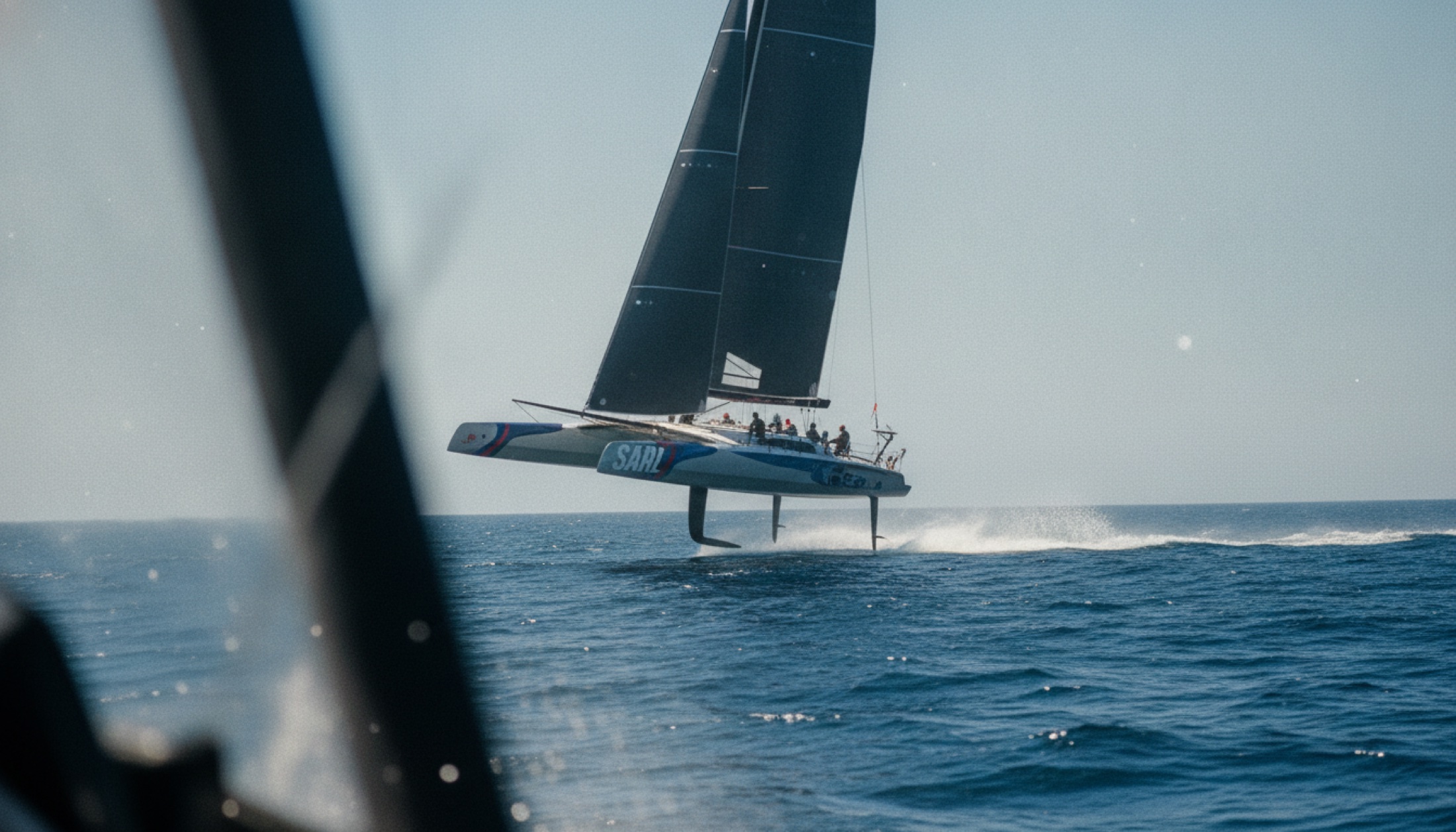 SailGP F50 foiling katamaranı yarış sırasında su üzerinde yükseliyor, açık deniz arka planı