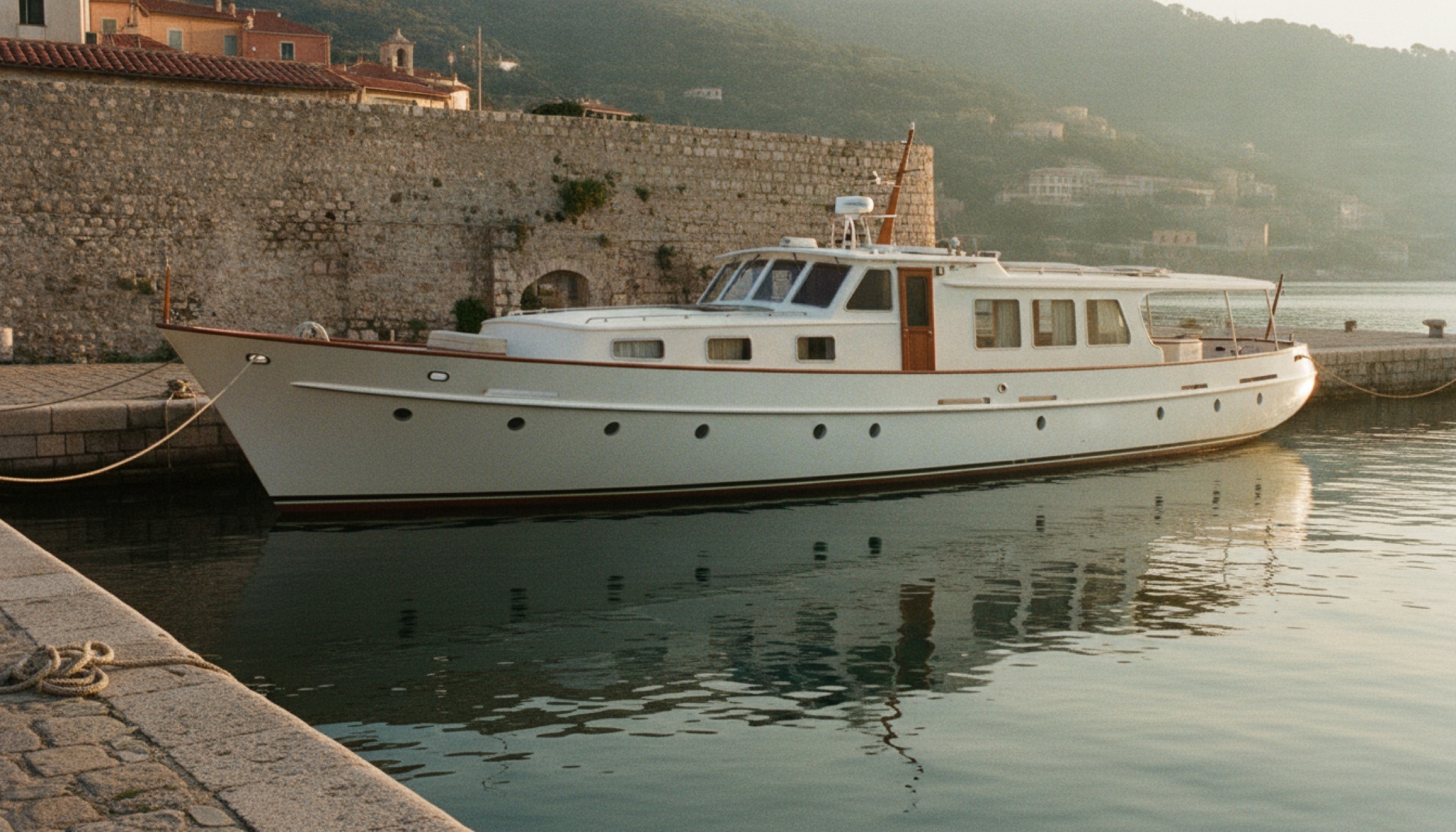 Sanlorenzo SHE Heritage 25.5 metre hibrit motor yat, navetta silüetiyle Akdeniz limanında