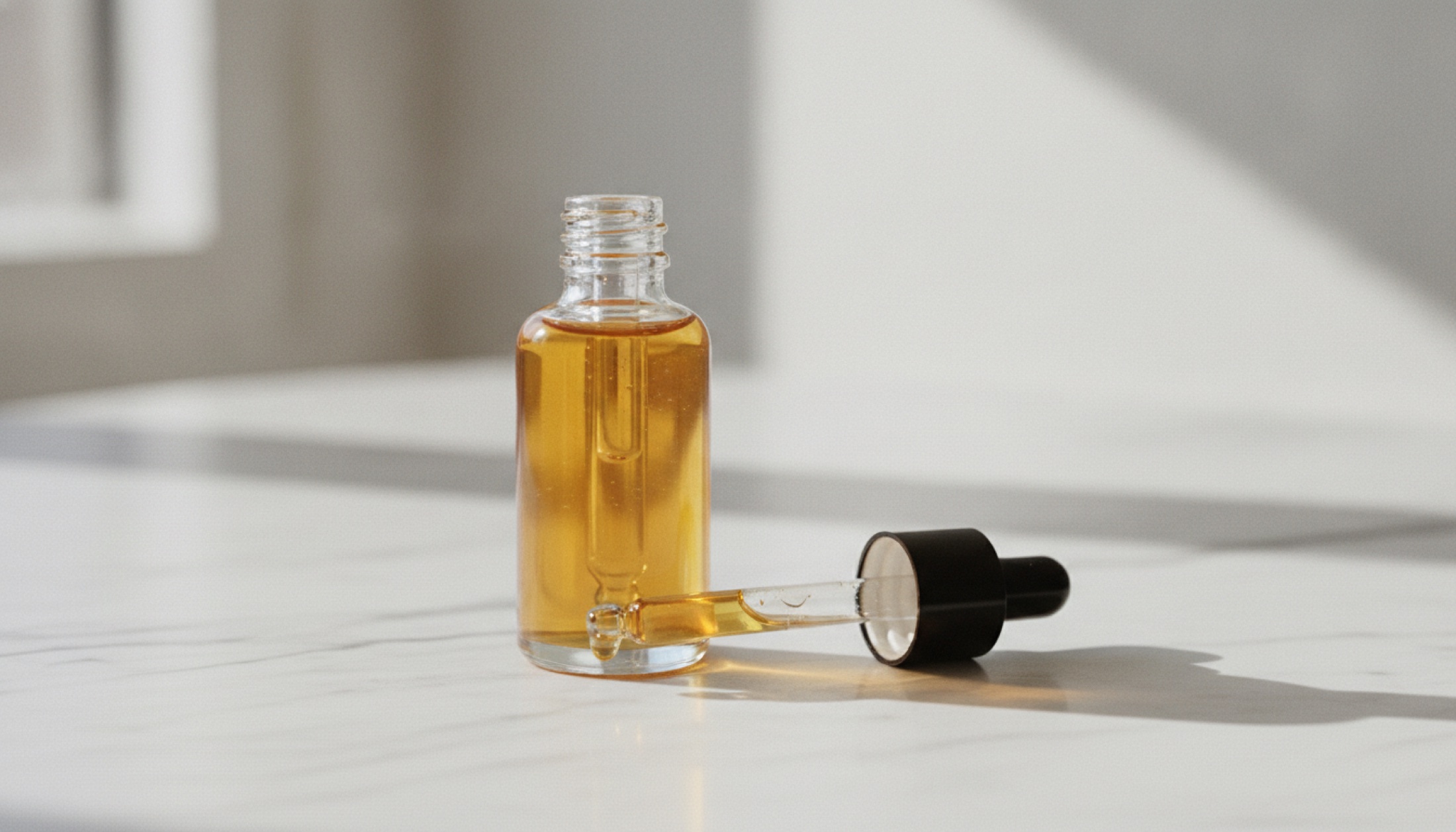 Mermer zemin üzerinde damlalıklı lüks serum şişesi, makro çekim