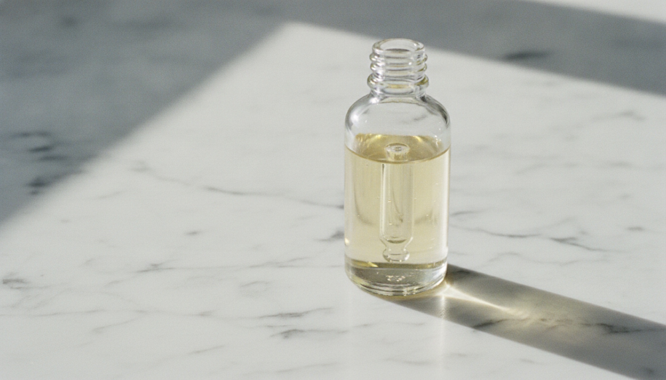 Mermer yüzey üzerinde bir serum şişesi, yan ışık