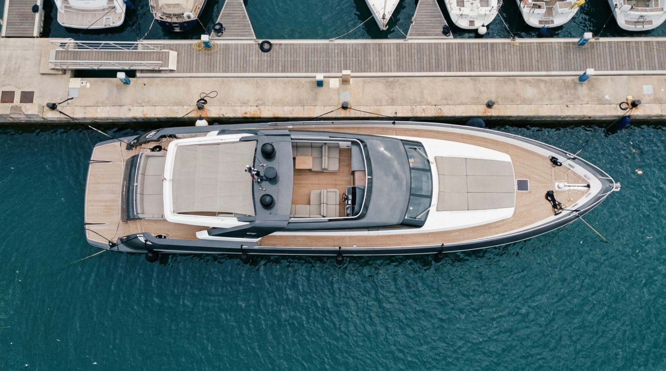 Wally WHY200 motoryatının geniş güverte ve dış hat tasarımı, marina yanaşmasında üstten bakış