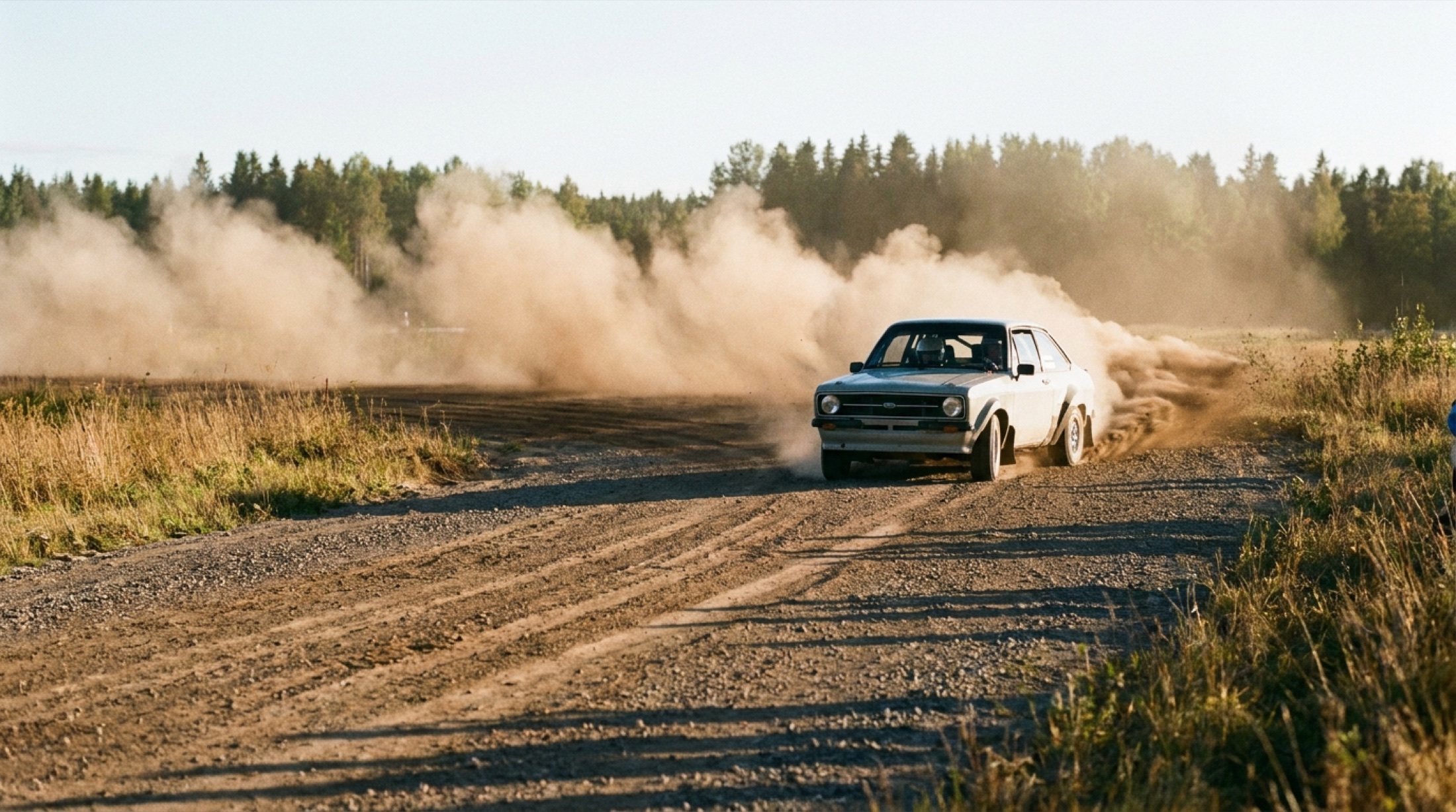 Ralli aracı toprak yolda toz bulutu içinde, arka tekerlek kaymalı
