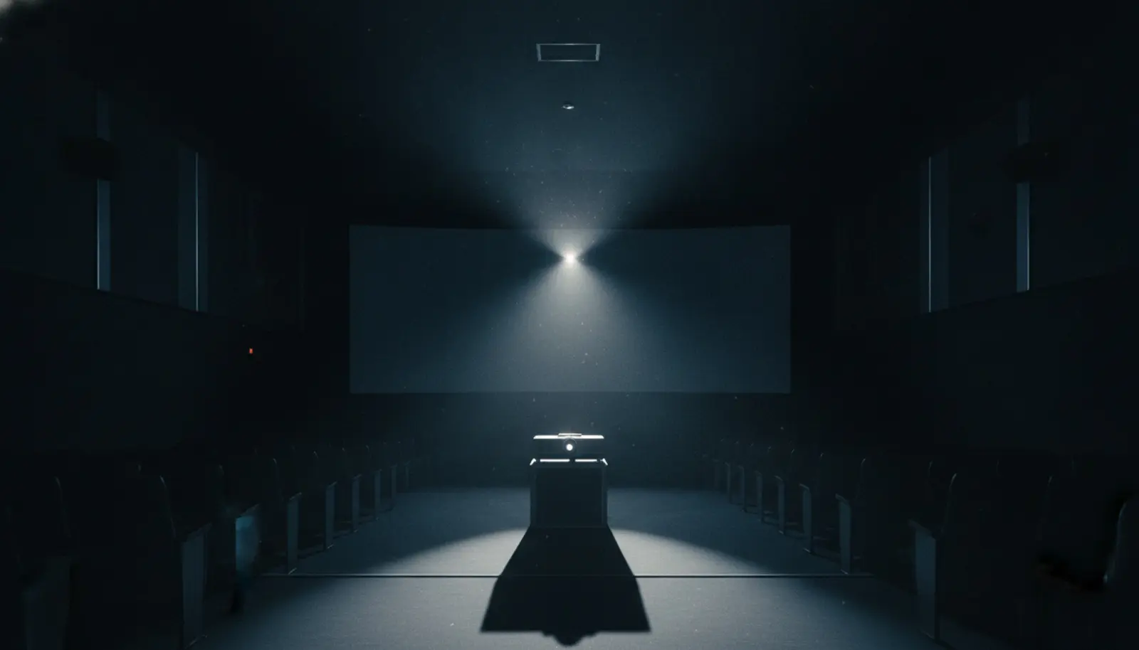 Karanlık bir sinema salonunda projeksiyon ışığı toza karışıyor